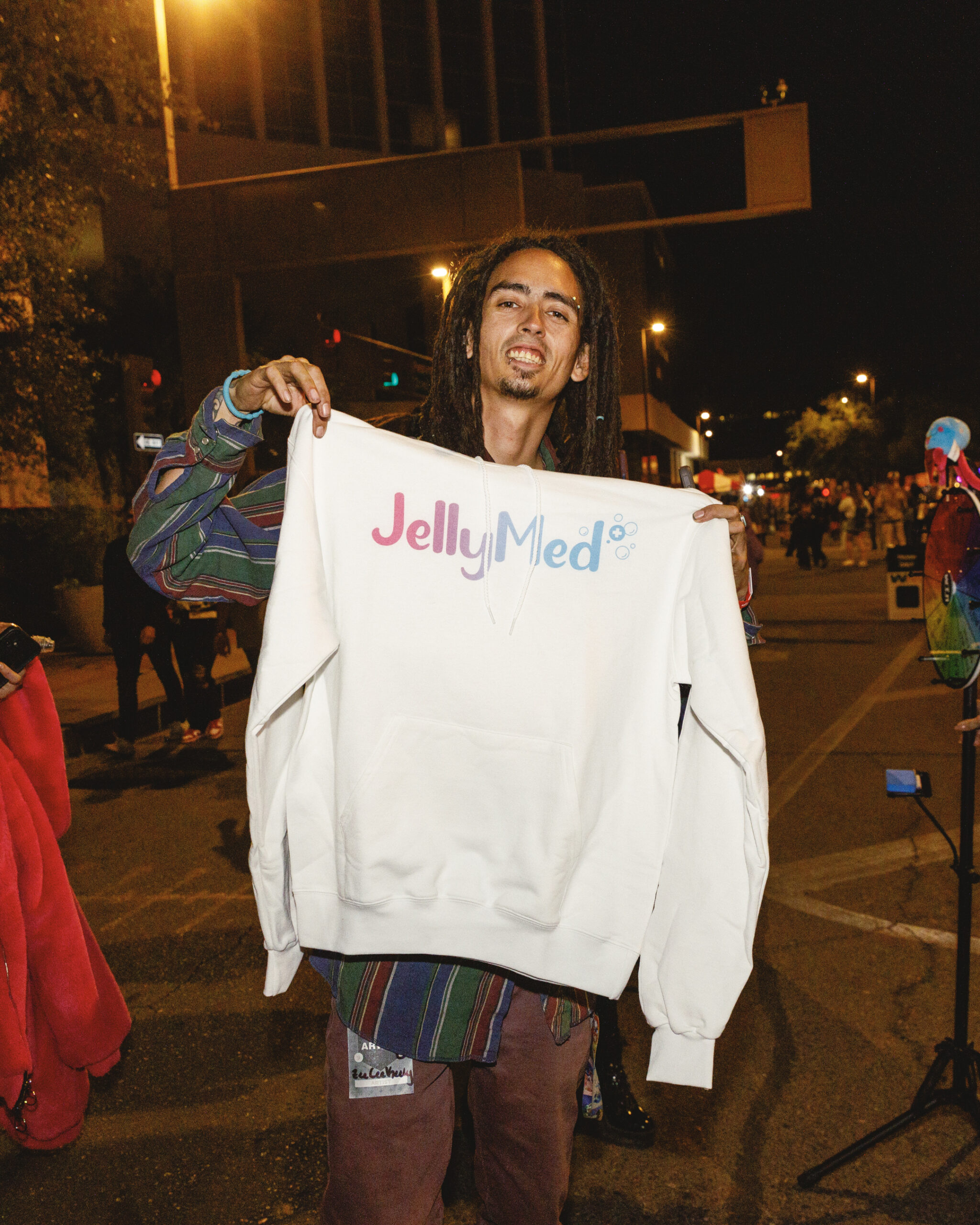 A festival guest holding up a JellyMed sweatshirt